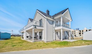 A two-story house with a balcony, a covered porch, and a garage. - Ostseesternchen - Sauna, washing machine, terrace, private parking space (Olpenitz)