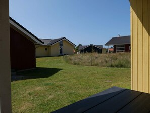 Ein Wohngebiet mit Häusern, einem Rasen und einer Holzterrasse.