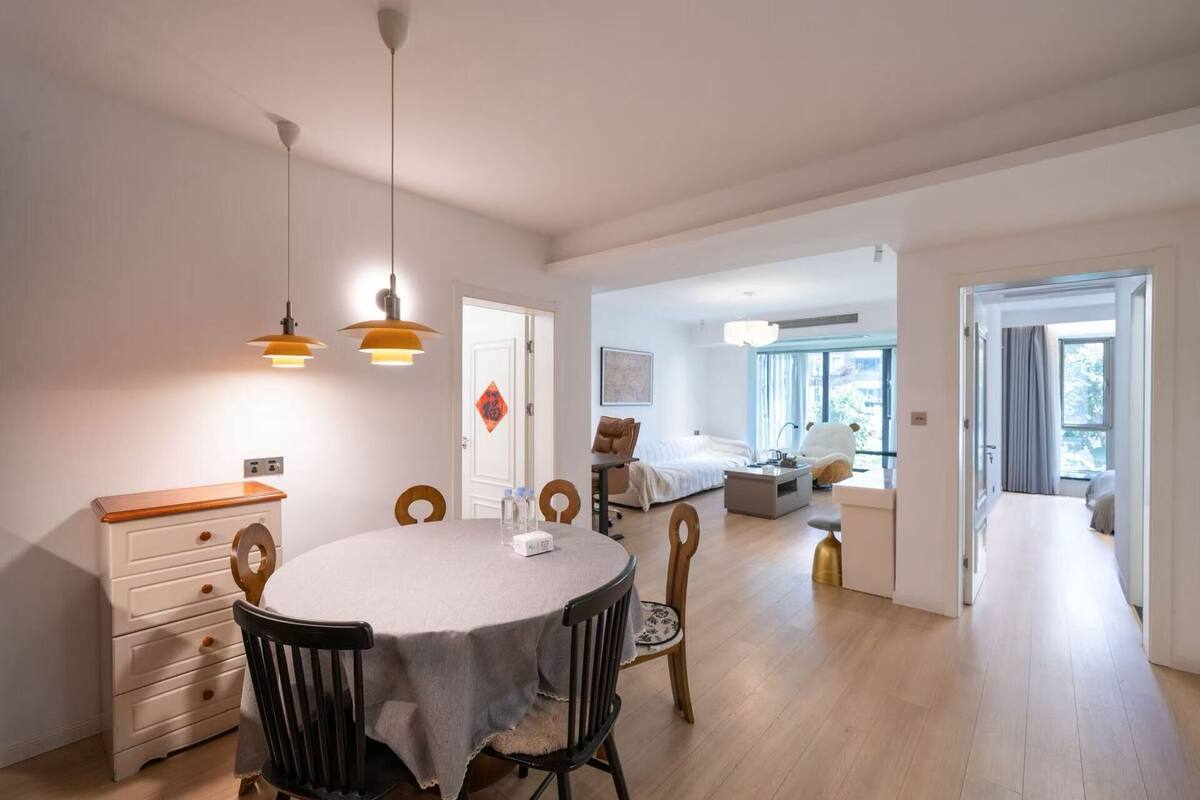 Moderni hotellihuone, jossa on ruokailutila, sänky ja näkymä ulos.