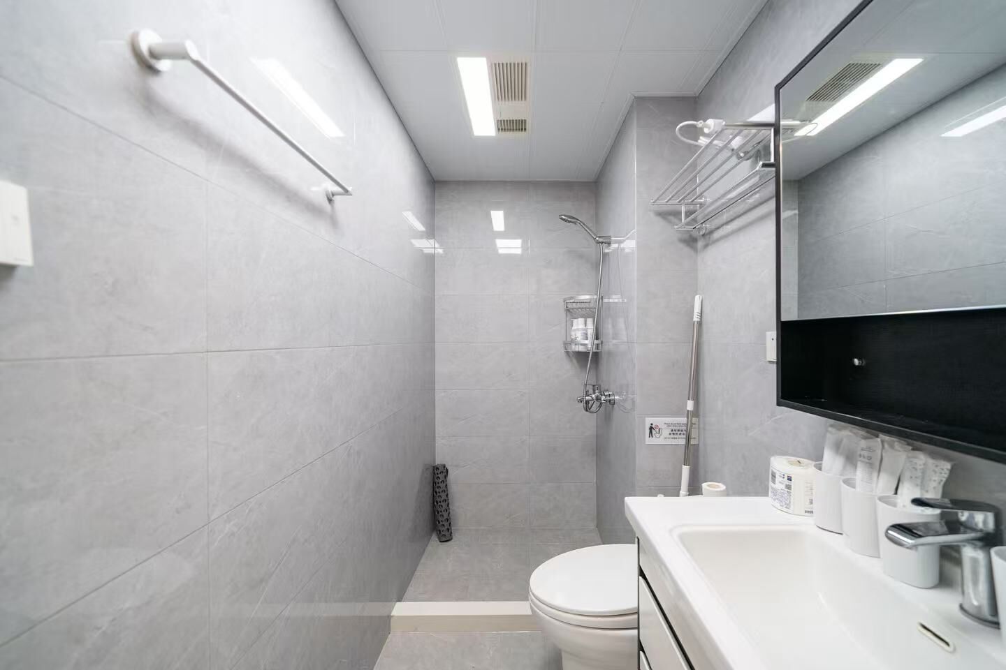 Un baño moderno con ducha, inodoro, lavabo y toallero.