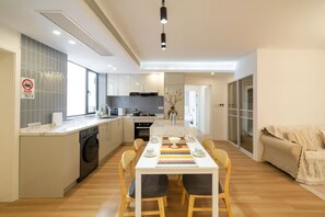 Una cocina moderna con comedor, lavadora y sofá.