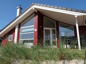 A red building with large windows and a white roof. - 4 Star Holiday Home in Grossenbrode (Grossenbrode)