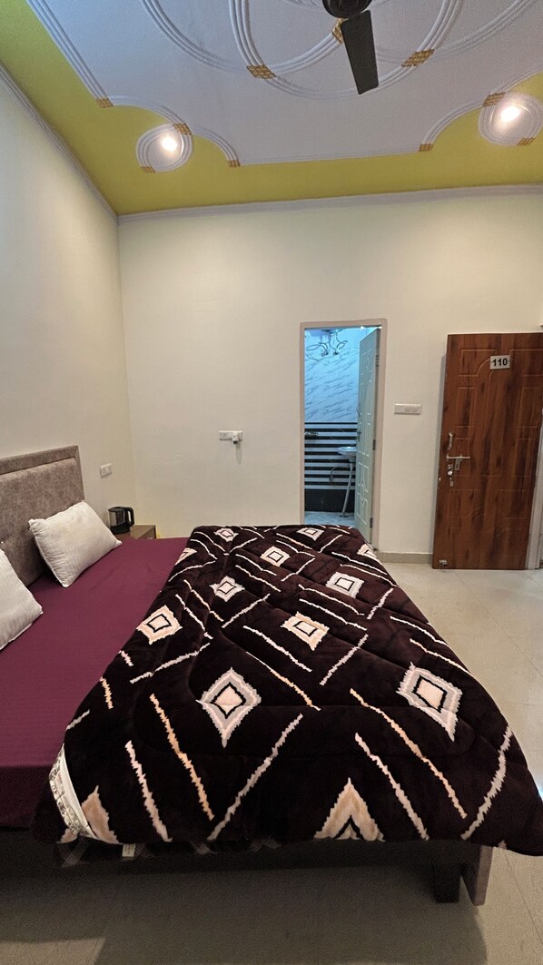 Ein Schlafzimmer mit Bett, Tür und Deckenventilator.