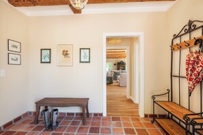 A hallway with a wooden bench, a coat rack, and framed botanical prints on the wall. - Vacation home Kreuzkate near Grömitz - Baltic Sea & fireplace (Manhagen)