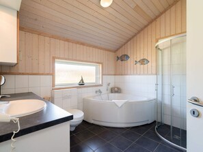 A bathroom with a bathtub, toilet, and sink. - 4 Star Holiday Home in Grossenbrode (Grossenbrode)