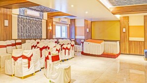 A conference room with rows of chairs, a stage, and a wooden ceiling. - Classic With Twin Bed , Pune Nagar (Pune)