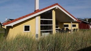 A yellow building with a red roof, a chimney, and a large window. - 4 Star Holiday Home in Grossenbrode (Grossenbrode)