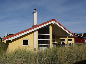 A yellow building with a red roof, a chimney, and a large window. - 4 Star Holiday Home in Grossenbrode (Grossenbrode)