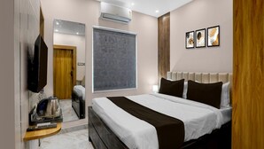 A modern hotel room with a large bed, a flat-screen TV, a coffee machine, and a window with a view. - Deluxehotel Pratee Heights (Bhubaneshwar)