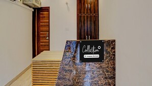 Un espace d’accueil doté d’un comptoir en marbre, de portes en bois et d’un plafond pourvu d’un éclairage encastré.