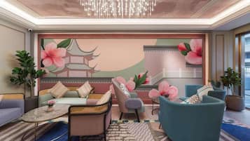 Uma sala de estar moderna com sofá, poltronas, mesa de centro e um mural decorativo.