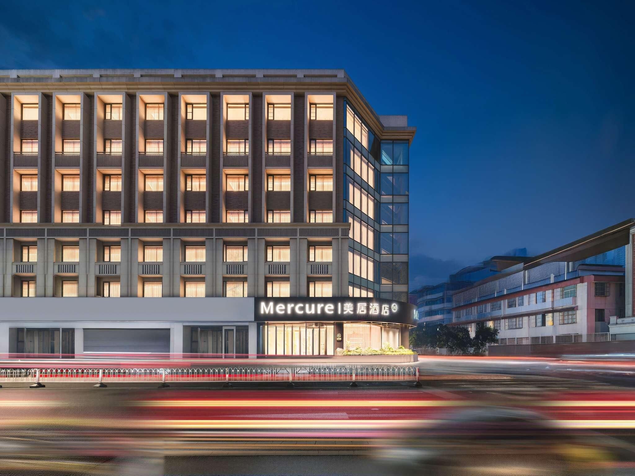 A multi-story hotel with a modern facade, large windows, and a prominent signage for 'Mercure'.