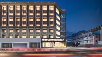 A multi-story hotel with a modern facade, large windows, and a prominent signage for 'Mercure'.