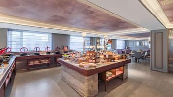 A buffet area with a marble island, multiple food stations, and seating arrangements.