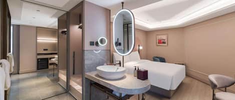 Una habitación de hotel moderna con un espejo redondo, una mesita de noche, una cama y una silla.