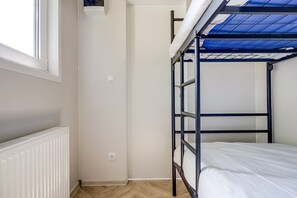 A bunk bed with a blue ceiling, a white radiator, and a window. - Cube 96 | 4 persoons chalet in Zennewijnen (Zennewijnen)