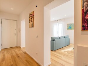 Eine moderne Wohnung mit Holzboden, einem hellblauen Sofa und Bildern an den Wänden.
