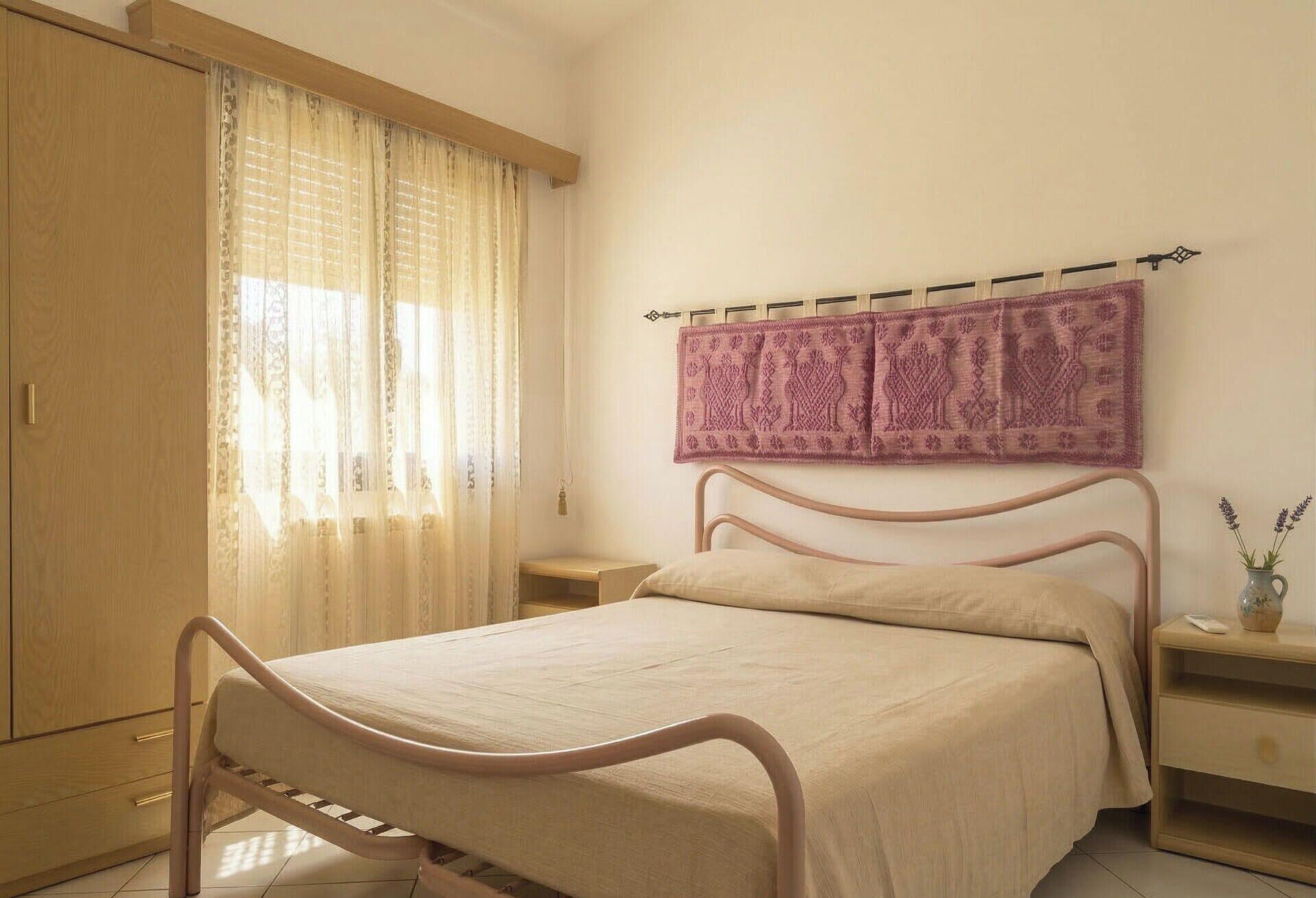 A bedroom with a bed, a wardrobe, a nightstand,