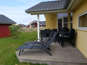 A patio with outdoor furniture, a covered seating area, and a view of neighboring houses. - Base With Private Sauna, Sun Deck (Grossenbrode)