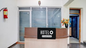 Un mostrador de recepción de hotel con un cartel que indica servicio corporativo.