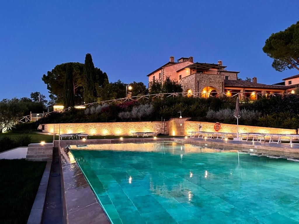 A swimming pool with a stone wall and a building in the background.