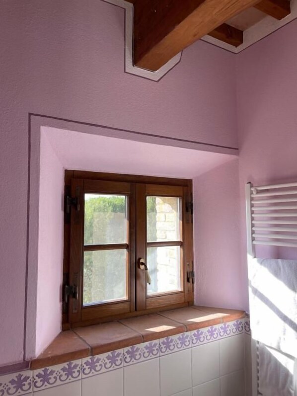 A bathroom with a window, a towel rack, and a tiled floor. - Villa Preselle Country Resort (Scansano)