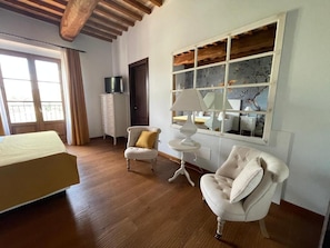 A room with a bed, two armchairs, a small table, a window with a view, and a cabinet. - Villa Preselle Country Resort (Preselle)