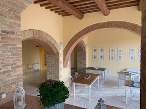 An interior with brick arches, a dining area with clear chairs, and framed pictures on the wall. - Villa Preselle Country Resort (Scansano)
