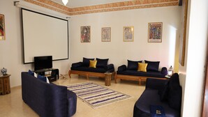 A living room with two sofas, a television, and decorative wall art. - Dar Yala, the Algerian home of hospitality and tradition. A haven of peace (Zéralda)