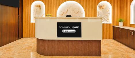 A reception desk with a sign indicating it is serviced by OYO.