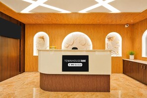 Un comptoir d’accueil avec une pancarte indiquant que le service est assuré par OYO.