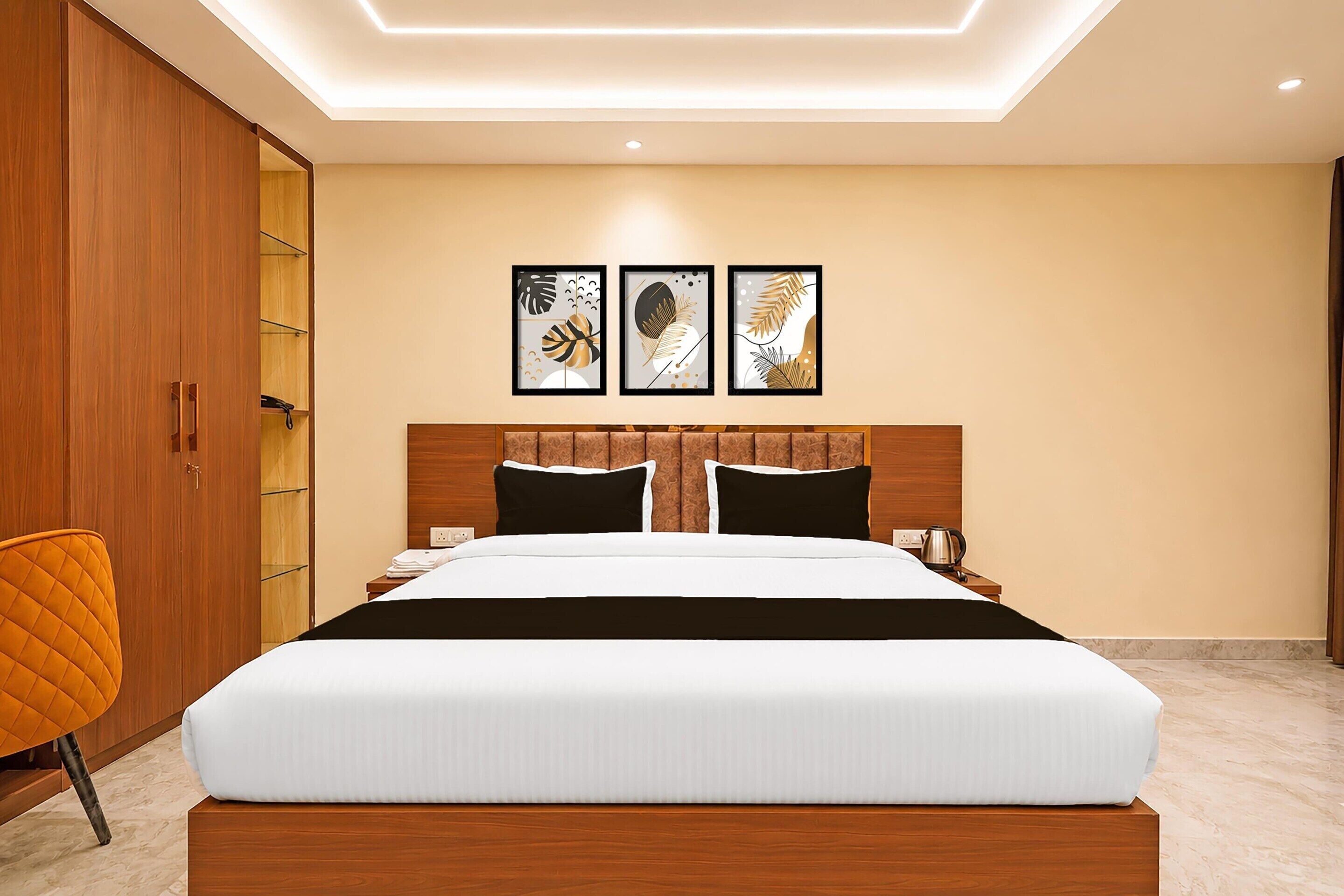 Una camera da letto moderna con un letto grande, una testiera in legno e tre quadri appesi al muro.