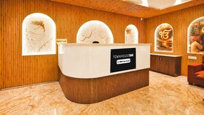 A reception desk with a sign indicating it is serviced by OYO.
