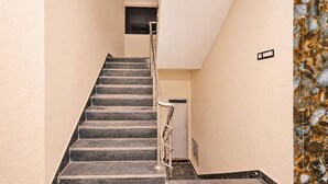 A staircase with a metal railing leading to an upper floor.