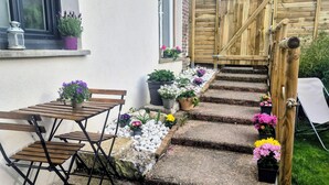 A wooden staircase leading to a garden area with potted plants and a wooden table with chairs. - Gîte: La Petite Maison de Vernon-Giverny. Wifi, Garden, Free Parking, Giverny (Vernon)