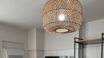 Une chambre à coucher comprenant un lit, un téléviseur fixé au mur, une étagère et un luminaire suspendu.