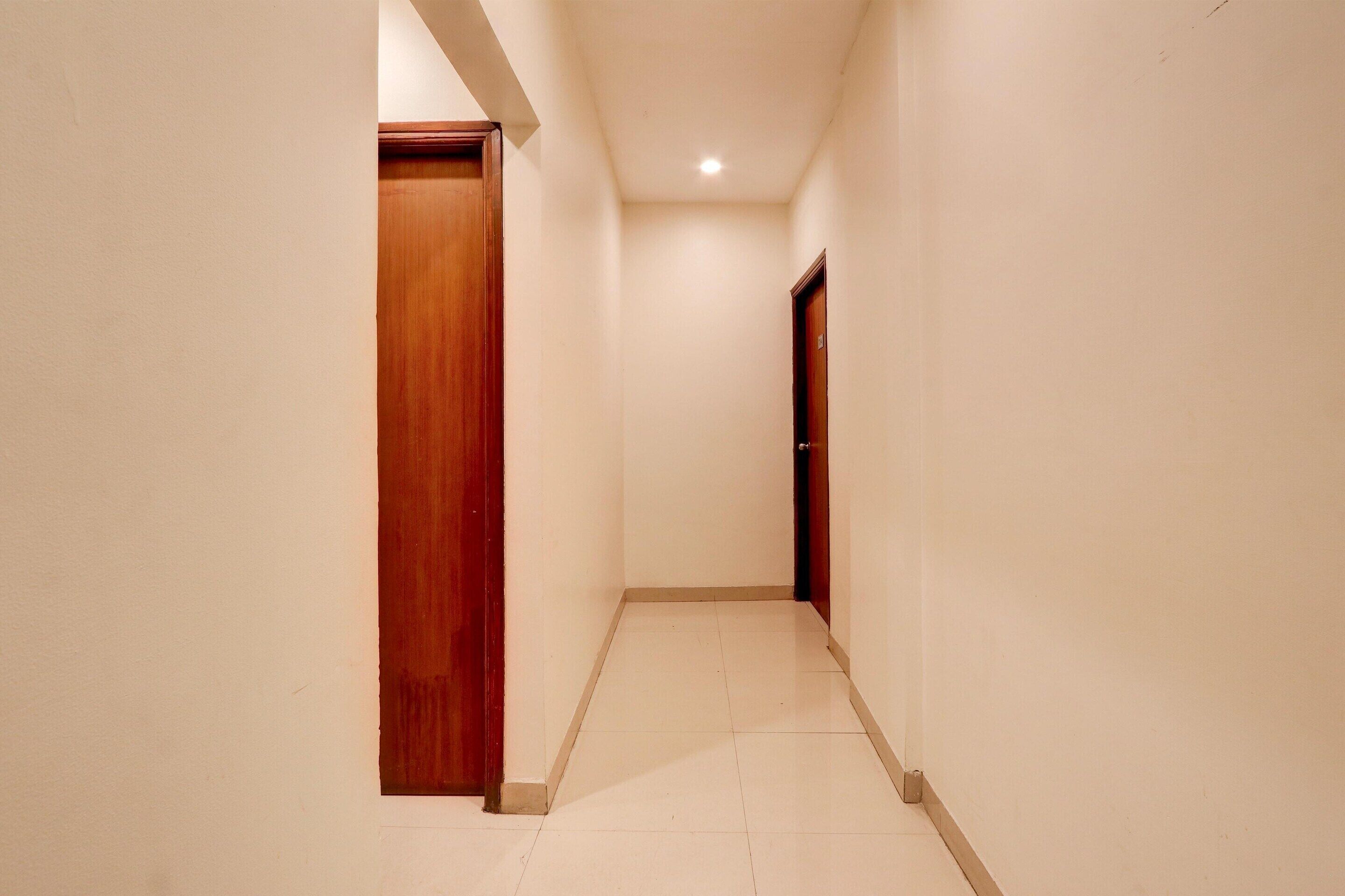 A narrow hallway with white walls and a tiled floor.