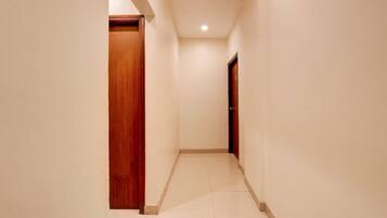 A narrow hallway with white walls and a tiled floor.