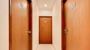 A corridor with wooden doors numbered 701 and 703, leading to a central door numbered 702.