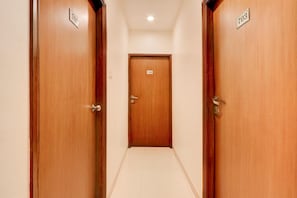A corridor with wooden doors numbered 701 and 703, leading to a central door numbered 702.