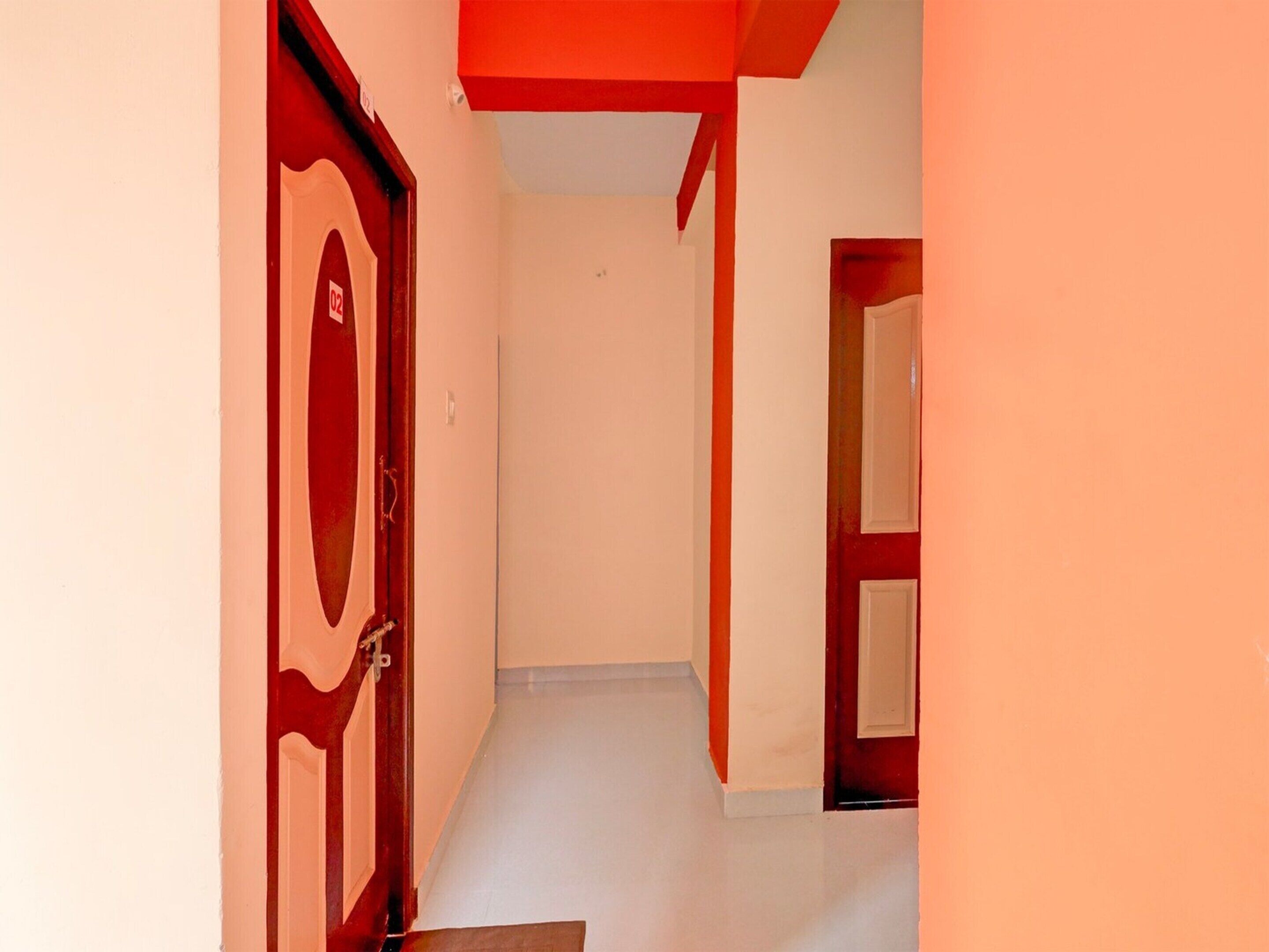 A corridor with red doors and white walls.