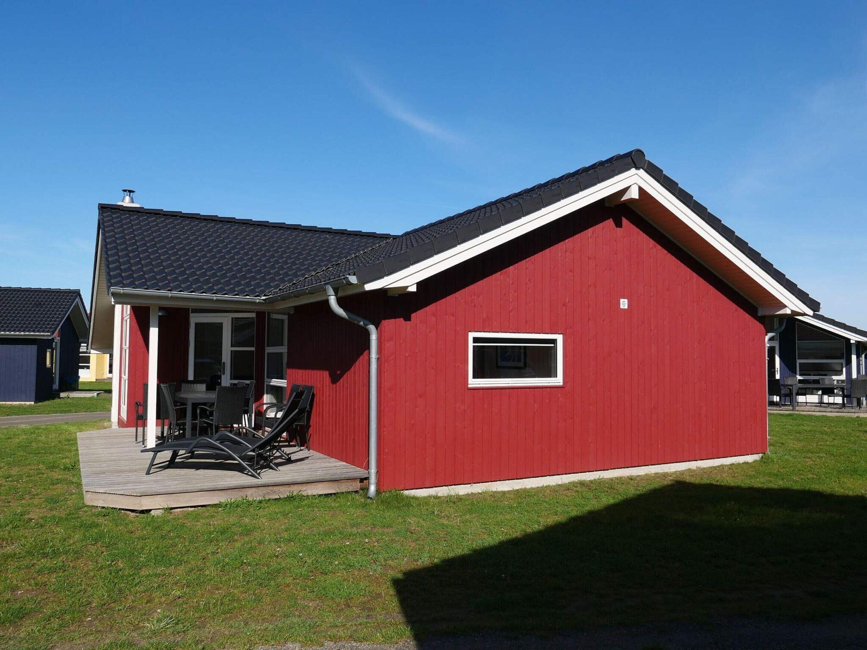 A red building with a porch and outdoor seating area.