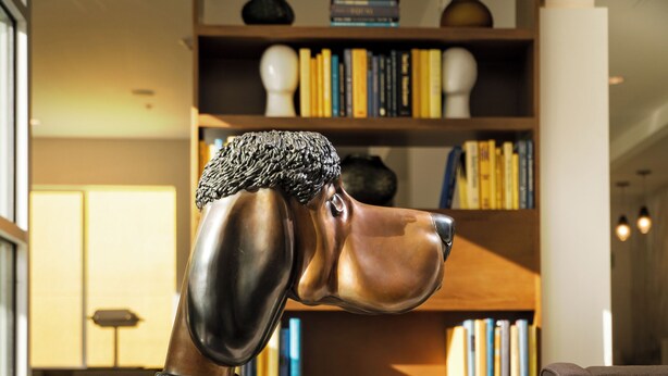 A sculpture of a dog in a modern living room with a bookshelf and a sofa. - Staypineapple, Hotel Z, Gaslamp San Diego (San Diego)