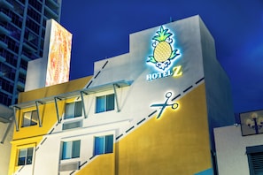 A hotel building with a prominent pineapple logo and the name 'HOTEL Z' on the facade.