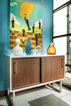 A modern interior with a wooden cabinet, decorative vases, and a wall art piece. - Hotel Z (San Diego)
