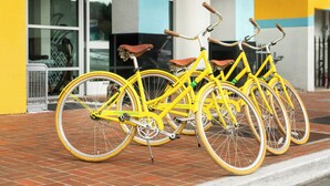 A row of yellow bicycles parked outside a building with a number '521' on the wall. - Staypineapple, Hotel Z, Gaslamp San Diego (San Diego)