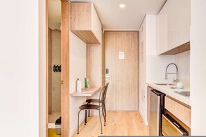 A compact kitchen with a built-in oven, a sink, and a small dining area with a chair. - w Distinct Loft in the Heart of Bogot (Bogotá)