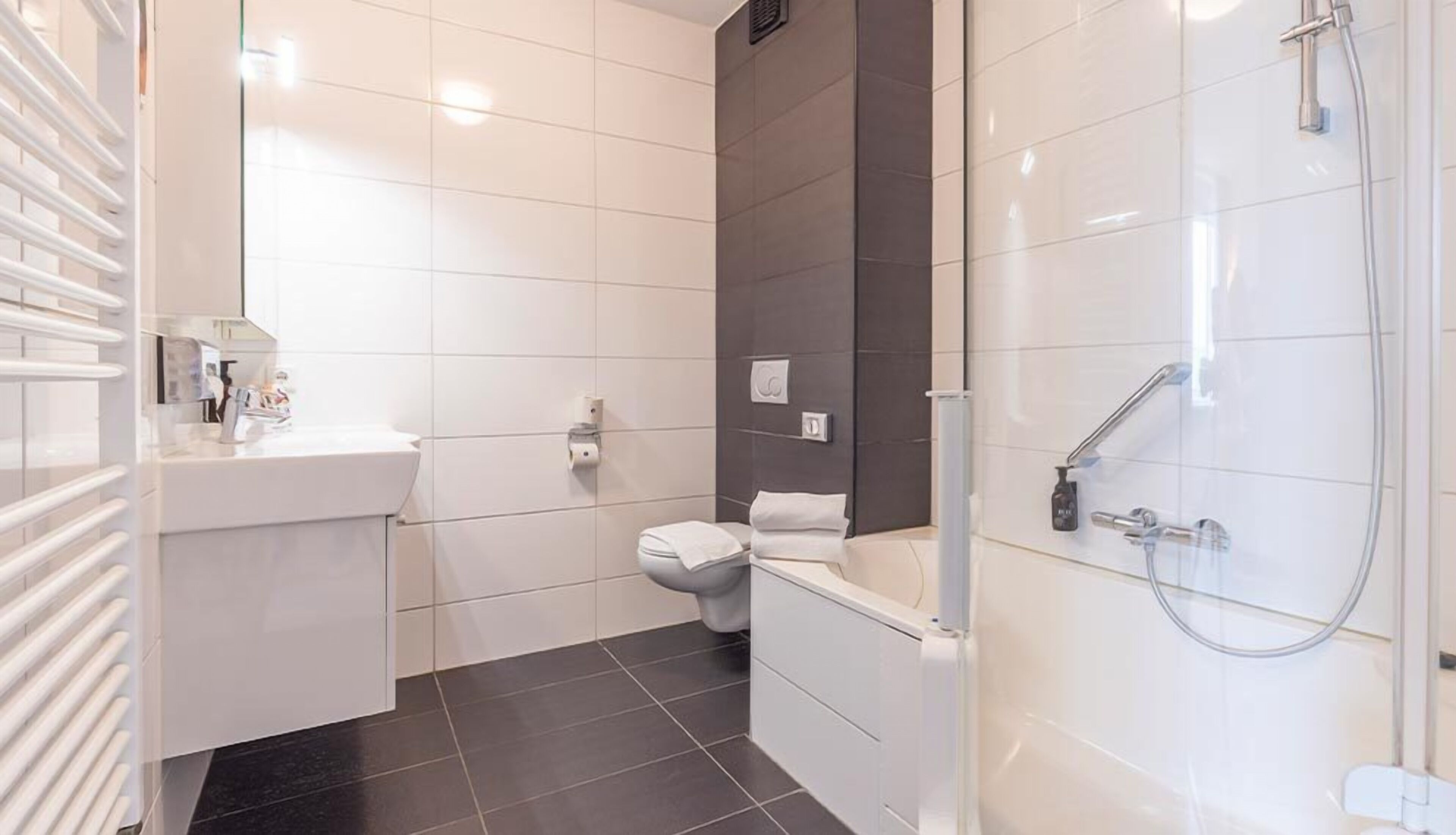 A modern bathroom with a toilet, sink, and shower.