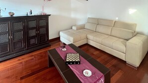 Un salon avec un canapé, une table basse en bois et un meuble en bois foncé.