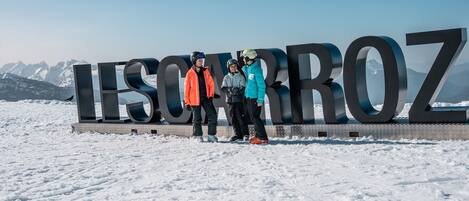 A large sign with the text 'LISMO ROZ' in a mountainous area with snow.